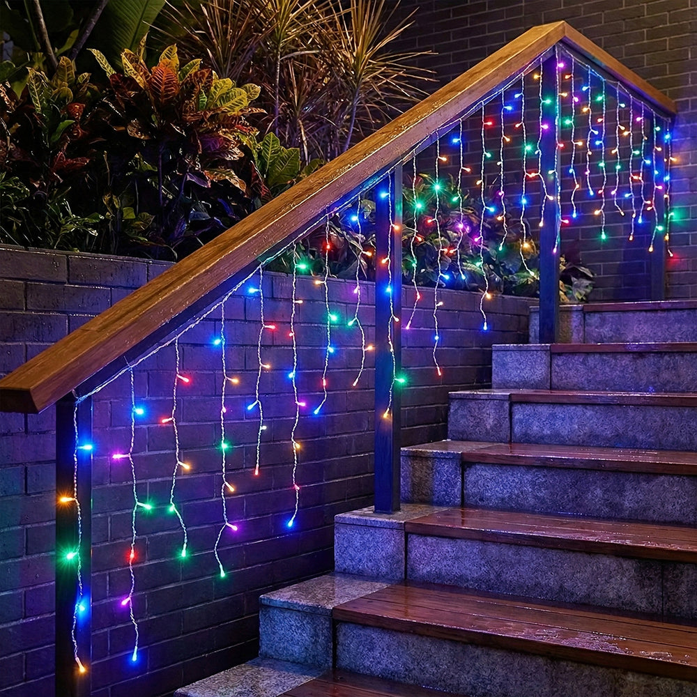 Garden Sanctuary solar-powered LED icicle string lights with remote control hanging outdoors, glowing with warm white light.