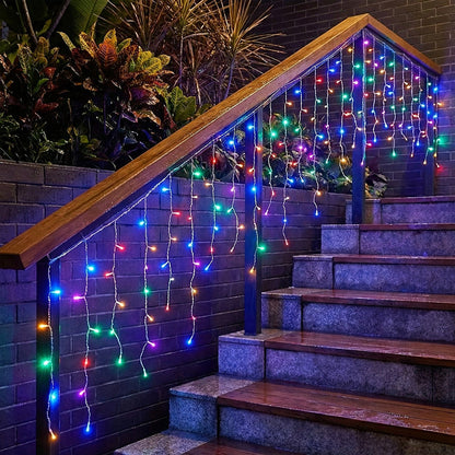 Garden Sanctuary solar-powered LED icicle string lights with remote control hanging outdoors, glowing with warm white light.