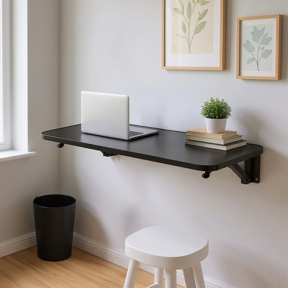 Wall-mounted folding table with iron brackets from Garden Sanctuary, showing a compact wooden surface and sturdy mounting hardware.