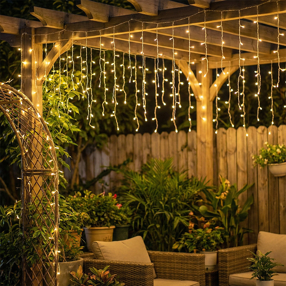 Solar-powered LED icicle string lights from Garden Sanctuary with remote control, hanging outdoors with warm glowing bulbs.